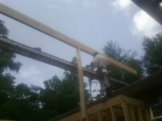 Carpenter setting a ridge beam over a new addition frame — Ice Dam Removal by Roofing Brothers in Moran
