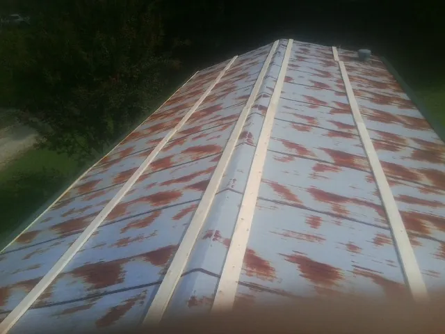Rusted metal roof panels with new wood purlins before replacement — Storm Damage Roof Repair in Moran by Roofing Brothers
